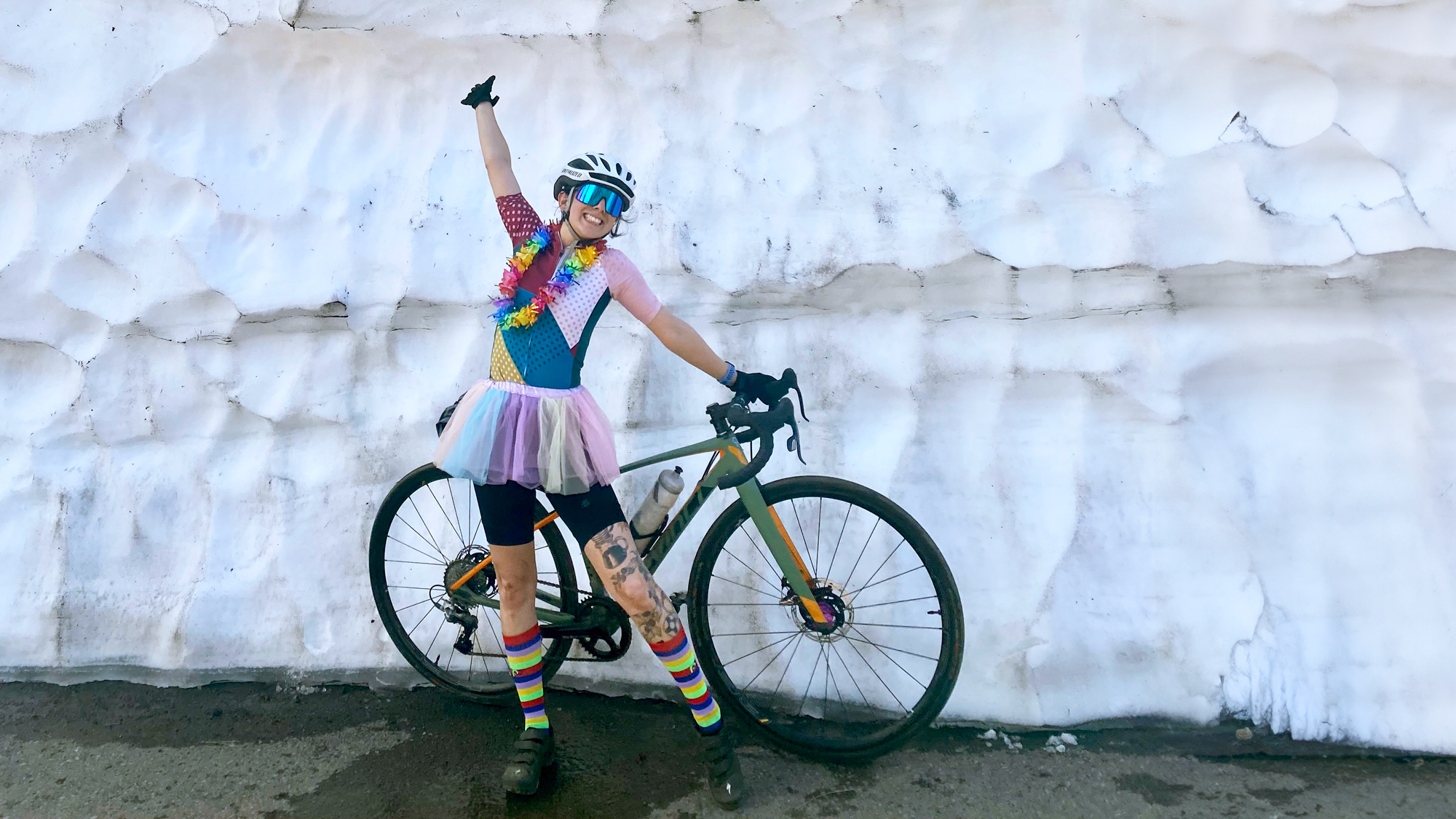 Becca Ruiz poses with her bike in front of huge snowbank.