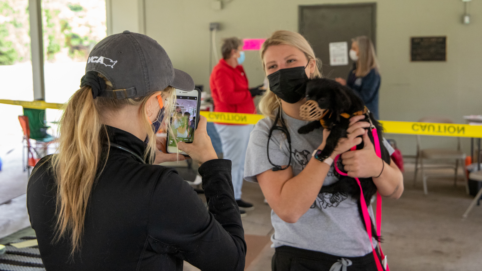 Shelter Medicine Club president Victoria Ryan poses for a photo with dog being treated at the event. 