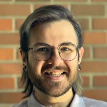 Christopher Larson portrait with brick background.